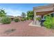 Relaxing backyard featuring a covered patio, lush shrubs, and a well-maintained gravel landscape at 2512 Desert Glen Dr, Las Vegas, NV 89134
