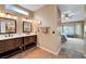 Bathroom featuring double vanities and access to the main bedroom with comfortable seating area and window at 2512 Desert Glen Dr, Las Vegas, NV 89134