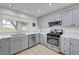 Bright kitchen featuring stainless appliances, gray cabinets, tile floors and white quartz countertops at 2512 Desert Glen Dr, Las Vegas, NV 89134