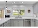 Bright kitchen featuring white countertops, gray cabinets, and a stainless steel dishwasher at 2512 Desert Glen Dr, Las Vegas, NV 89134