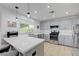 Bright kitchen with stainless appliances, gray cabinets, breakfast bar, tile floors and white quartz countertops at 2512 Desert Glen Dr, Las Vegas, NV 89134
