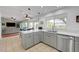 Bright kitchen with tile floors, white counters and gray cabinets open to living and dining areas at 2512 Desert Glen Dr, Las Vegas, NV 89134