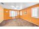 Cozy bedroom with neutral carpeting, ceiling fan, bright window with shutter and orange accent wall at 2707 Commitment Ct, North Las Vegas, NV 89031