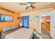 Bedroom boasts ceiling fan, carpeting, natural light, and orange accent walls at 2707 Commitment Ct, North Las Vegas, NV 89031