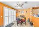 Charming dining area featuring a ceiling fan, sliding glass door, and orange-painted walls at 2707 Commitment Ct, North Las Vegas, NV 89031