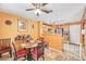 Inviting dining area adjacent to the kitchen with a ceiling fan and orange-painted walls at 2707 Commitment Ct, North Las Vegas, NV 89031