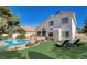 An inviting backyard with a sparkling pool, lush green lawn, and comfortable lounge chairs at 2714 Cricket Hollow Ct, Henderson, NV 89074