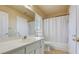 Well-lit bathroom features a white vanity, toilet, and shower with white shower curtain at 2714 Cricket Hollow Ct, Henderson, NV 89074