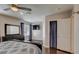 Spacious bedroom featuring an ensuite bathroom, wood floors, a ceiling fan, and dark wood furnishings at 2714 Cricket Hollow Ct, Henderson, NV 89074