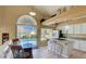 Bright kitchen featuring granite countertops, breakfast bar, white cabinetry, and poolside dining at 2714 Cricket Hollow Ct, Henderson, NV 89074