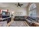 The living room offers a sleek sectional sofa, a ceiling fan and ample natural light at 2714 Cricket Hollow Ct, Henderson, NV 89074
