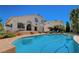 Gorgeous backyard pool with steps and a view of the two-story home featuring large windows at 2714 Cricket Hollow Ct, Henderson, NV 89074