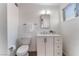 Bathroom featuring a toilet, sink with countertop and vanity, a mirror, and a window at 2825 Hickey Ave, North Las Vegas, NV 89030