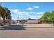 Charming single-story home with a gated yard, desert landscaping, and mature trees at 2825 Hickey Ave, North Las Vegas, NV 89030