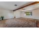Spacious living room featuring neutral carpet, a wooden beam, and a bright window at 2825 Hickey Ave, North Las Vegas, NV 89030
