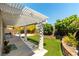 Charming backyard with a covered patio, artificial grass, and landscaped garden at 3300 Uribe St, Las Vegas, NV 89129