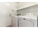 Bright laundry room featuring white appliances, shelving, and a convenient utility closet at 3300 Uribe St, Las Vegas, NV 89129