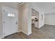 Open-concept foyer with neutral walls, wood floors, white door, and views into the kitchen and living spaces at 3365 Moon Eclipse St, North Las Vegas, NV 89032