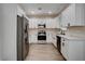 Well-lit kitchen with white cabinets, marble countertops, and stainless steel appliances at 3365 Moon Eclipse St, North Las Vegas, NV 89032