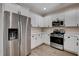 Kitchen with stainless steel appliances, white cabinets, quartz countertops and modern flooring at 3365 Moon Eclipse St, North Las Vegas, NV 89032