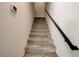 Carpeted stairway with a black handrail leads to the upper level of this modern home at 3365 Moon Eclipse St, North Las Vegas, NV 89032