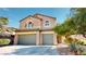 Inviting two-story home boasts a three-car garage, desert landscaping, and a charming terracotta roof at 3425 Fledgling Dr, North Las Vegas, NV 89084