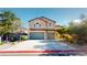 Charming two-story home boasts a three-car garage, mature trees, and beautiful desert landscaping at 3425 Fledgling Dr, North Las Vegas, NV 89084
