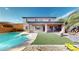 Spacious backyard with covered patio, pool, and desert landscaping creates a private oasis at 3425 Fledgling Dr, North Las Vegas, NV 89084