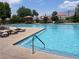 Community pool area with lounge chairs, umbrellas, and mountain views on a bright day at 3425 Fledgling Dr, North Las Vegas, NV 89084