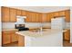 Well-lit kitchen featuring wood cabinets, an island with sink, and modern appliances for cooking at 4007 W Red Coach Ave, North Las Vegas, NV 89031