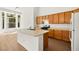 Bright kitchen features wood cabinets, an island with sink, and natural light for a welcoming atmosphere at 4007 W Red Coach Ave, North Las Vegas, NV 89031