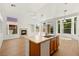 Open kitchen offers an island with sink, wood cabinets, and seamless flow to living areas for entertaining at 4007 W Red Coach Ave, North Las Vegas, NV 89031