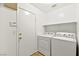 Cozy laundry room with a white washer and dryer, a utility door, and a storage shelf at 4007 W Red Coach Ave, North Las Vegas, NV 89031