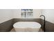 Modern bathtub with black faucet overlooking the backyard pool through a bright window at 4016 Tyler William Ln, Las Vegas, NV 89130