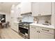 Well-appointed kitchen featuring white cabinetry, stainless steel appliances, and a modern range hood at 4016 Tyler William Ln, Las Vegas, NV 89130