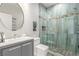 Modern bathroom with a walk-in shower featuring blue tile, glass doors, and a gray vanity at 44 Tamarron Cliffs St, Las Vegas, NV 89148