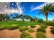 Landscaped entrance to Rhodes Ranch showcases a welcoming sign amidst lush greenery and palm trees at 44 Tamarron Cliffs St, Las Vegas, NV 89148