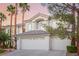 Elegant two-story home boasting a three-car garage, palm trees, and well-maintained landscaping at 44 Tamarron Cliffs St, Las Vegas, NV 89148