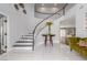 Bright, welcoming foyer featuring a curved staircase, table with flowers, and tiled flooring at 44 Tamarron Cliffs St, Las Vegas, NV 89148