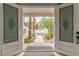 Inviting view through the front doors revealing a landscaped yard and palm trees at 44 Tamarron Cliffs St, Las Vegas, NV 89148
