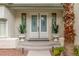 Close-up of the front entrance featuring double doors, potted plants, and decorative lighting at 44 Tamarron Cliffs St, Las Vegas, NV 89148