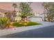 Beautiful home with manicured lawn, mature trees, landscape lighting, and a circular driveway at 44 Tamarron Cliffs St, Las Vegas, NV 89148