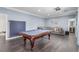 Spacious game room with a pool table, sectional sofa, and modern decor at 44 Tamarron Cliffs St, Las Vegas, NV 89148