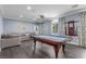 Spacious game room with a pool table, a comfortable sofa, and elegant curtains at 44 Tamarron Cliffs St, Las Vegas, NV 89148