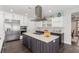 This kitchen boasts stainless steel appliances, a central island with cooktop, and modern white and grey cabinetry at 44 Tamarron Cliffs St, Las Vegas, NV 89148