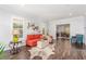 Inviting living room with a red sofa, hardwood floors, and bright natural light from large windows at 44 Tamarron Cliffs St, Las Vegas, NV 89148