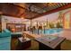 Covered patio features outdoor seating, a built-in grill, and a fire pit, ideal for entertaining near the pool at 44 Tamarron Cliffs St, Las Vegas, NV 89148