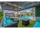 Inviting covered patio boasts outdoor seating, fire pit, built-in grill, and a view of the sparkling pool at 44 Tamarron Cliffs St, Las Vegas, NV 89148