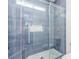 Modern shower featuring glass doors, blue tile, and a built-in shelf, providing a luxurious bathing experience at 44 Tamarron Cliffs St, Las Vegas, NV 89148
