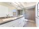 Bathroom with dual sinks, grey counters, and a glass shower at 5705 Sovereign Way, Las Vegas, NV 89130
